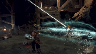 Kratos y Atreus luchan contra un enemigo en una cueva.