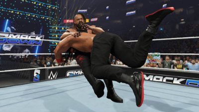 WWE 2K25 screenshot showing Roman Reigns delivering a spear to Jacob Fatu